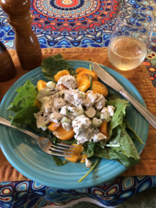 Chicken salad with tomato and lettuce on a blue plate.