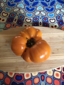 A large heirloom tomato, orange. 