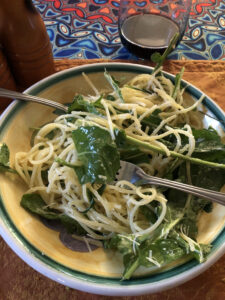 Pasta and arugula salad in a yellow bowl. 