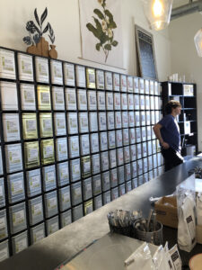 A long wall of square boxes that contain loose tea leaves. 