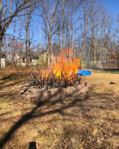 A raging fire in an old brick barbecue in the middle of a field.